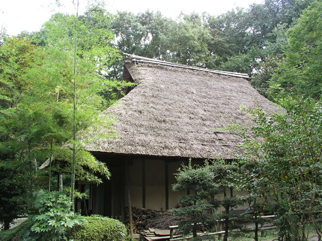 茅葺き屋根の民家と竹林